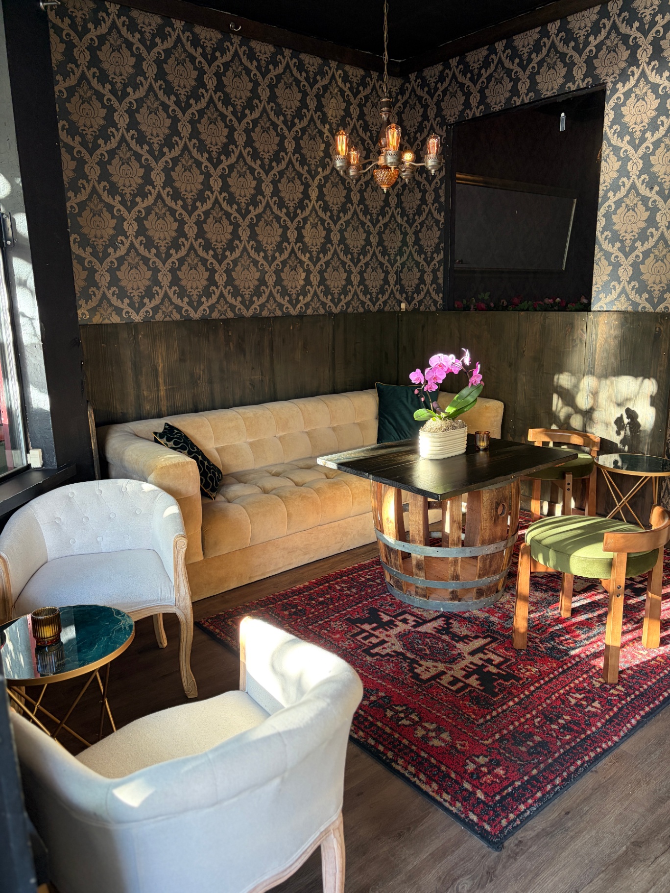 Gold damask lounge with velvet sofas and chandelier