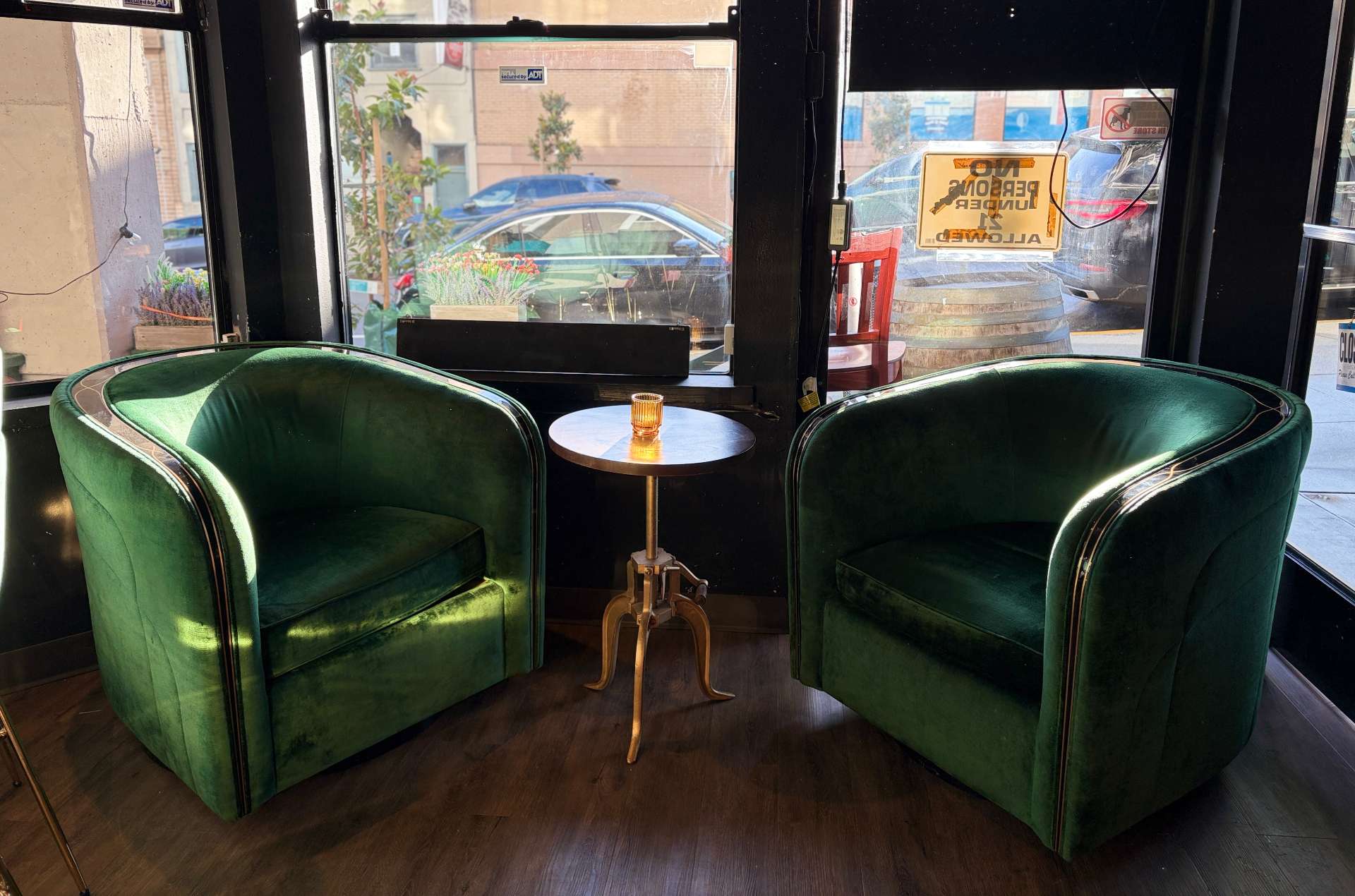 Two emerald velvet chairs by the window at Flying Figs