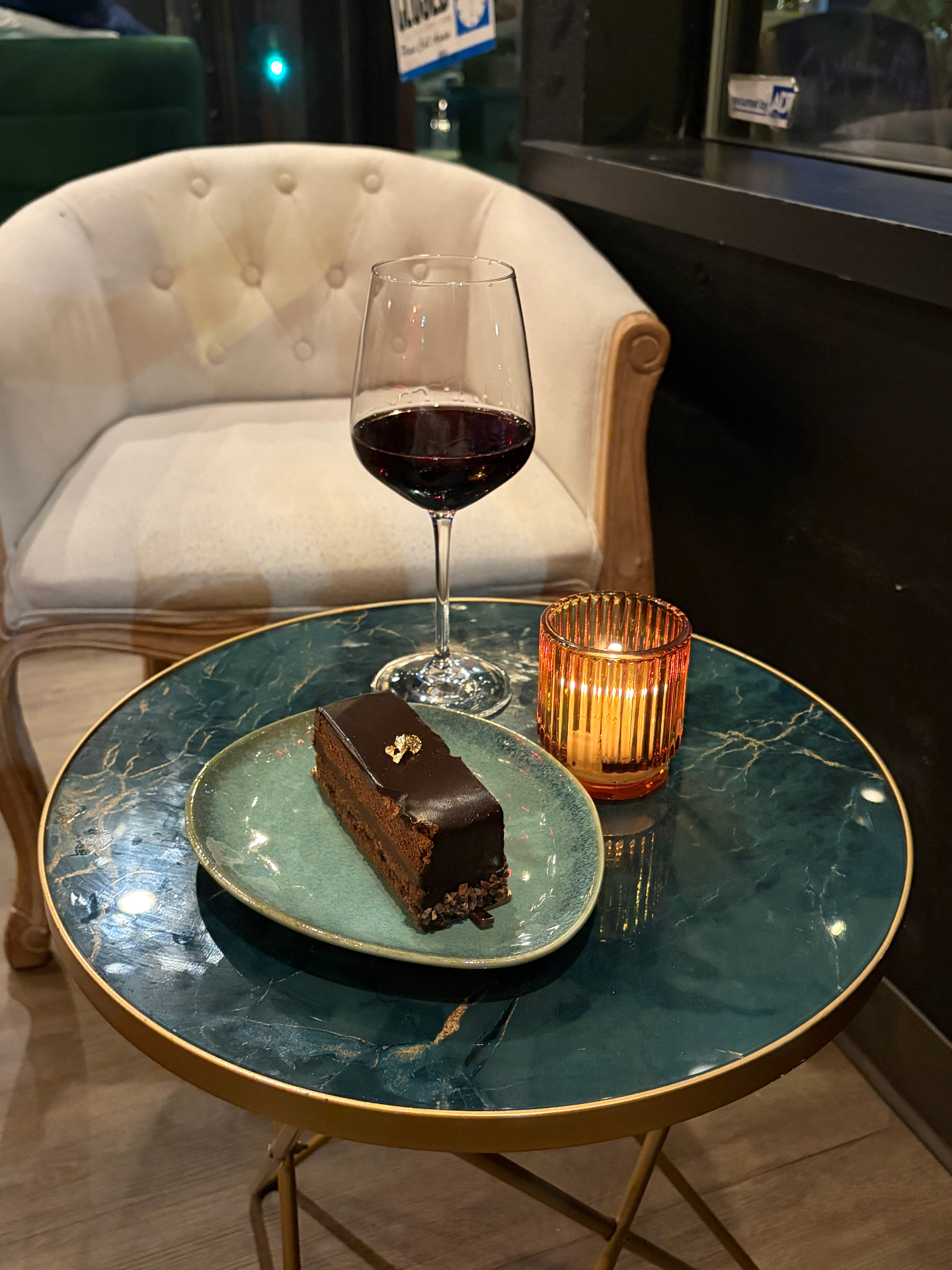 Glass of red wine and chocolate cake by candlelight
